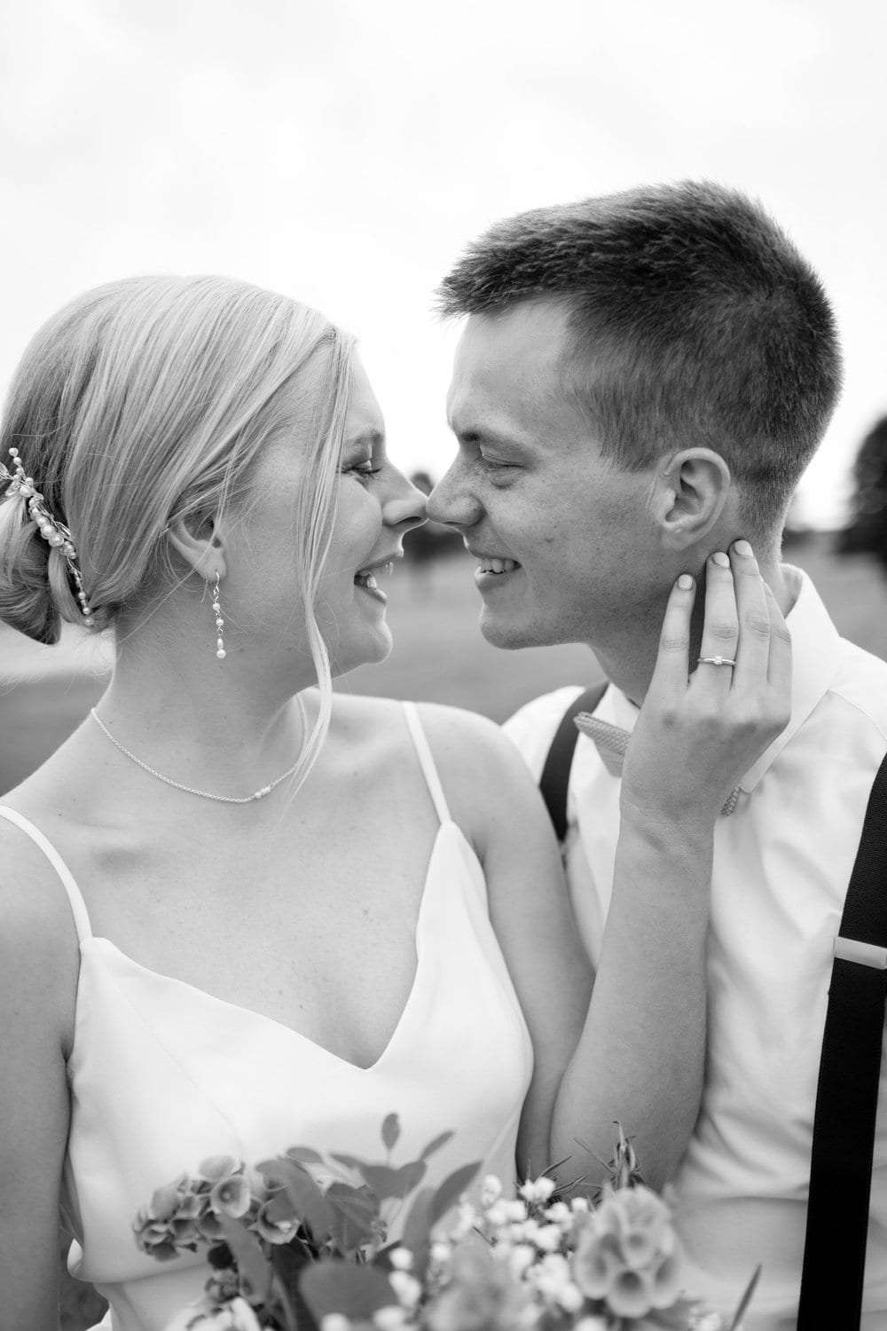 Baiser complice des mariés, la mariée tient son bouquet