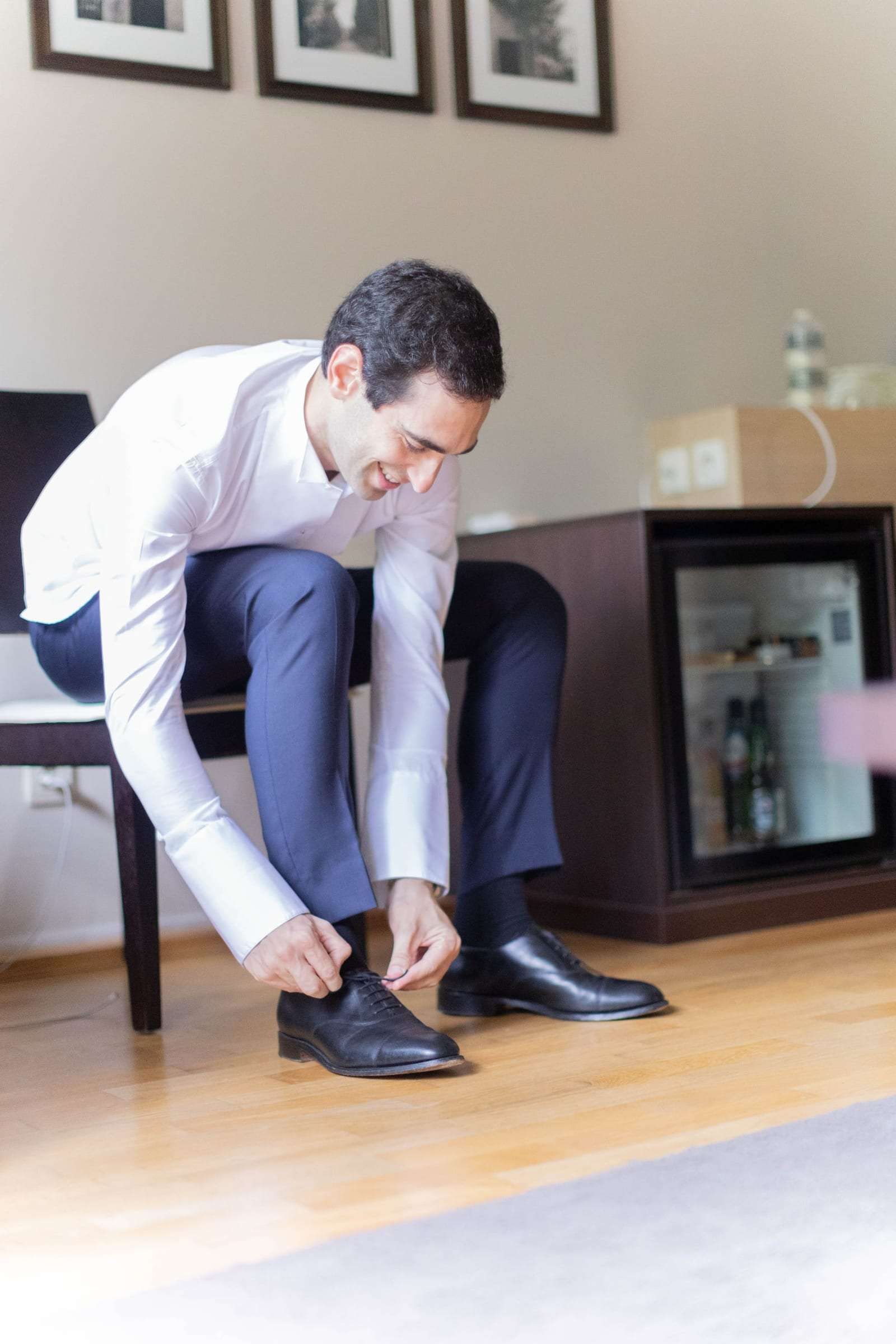 Le marié lace ses chaussures dans sa chambre