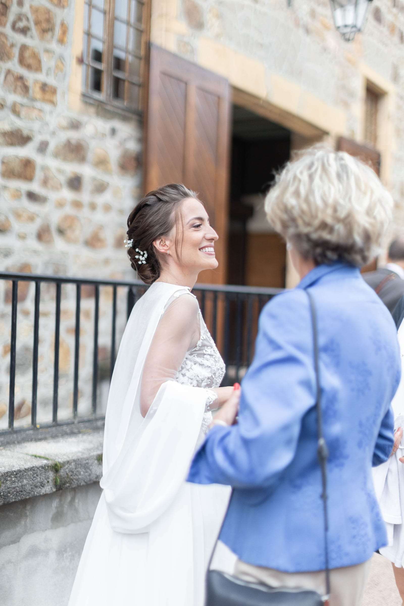 La mariée échange avec une invitée sur le perron