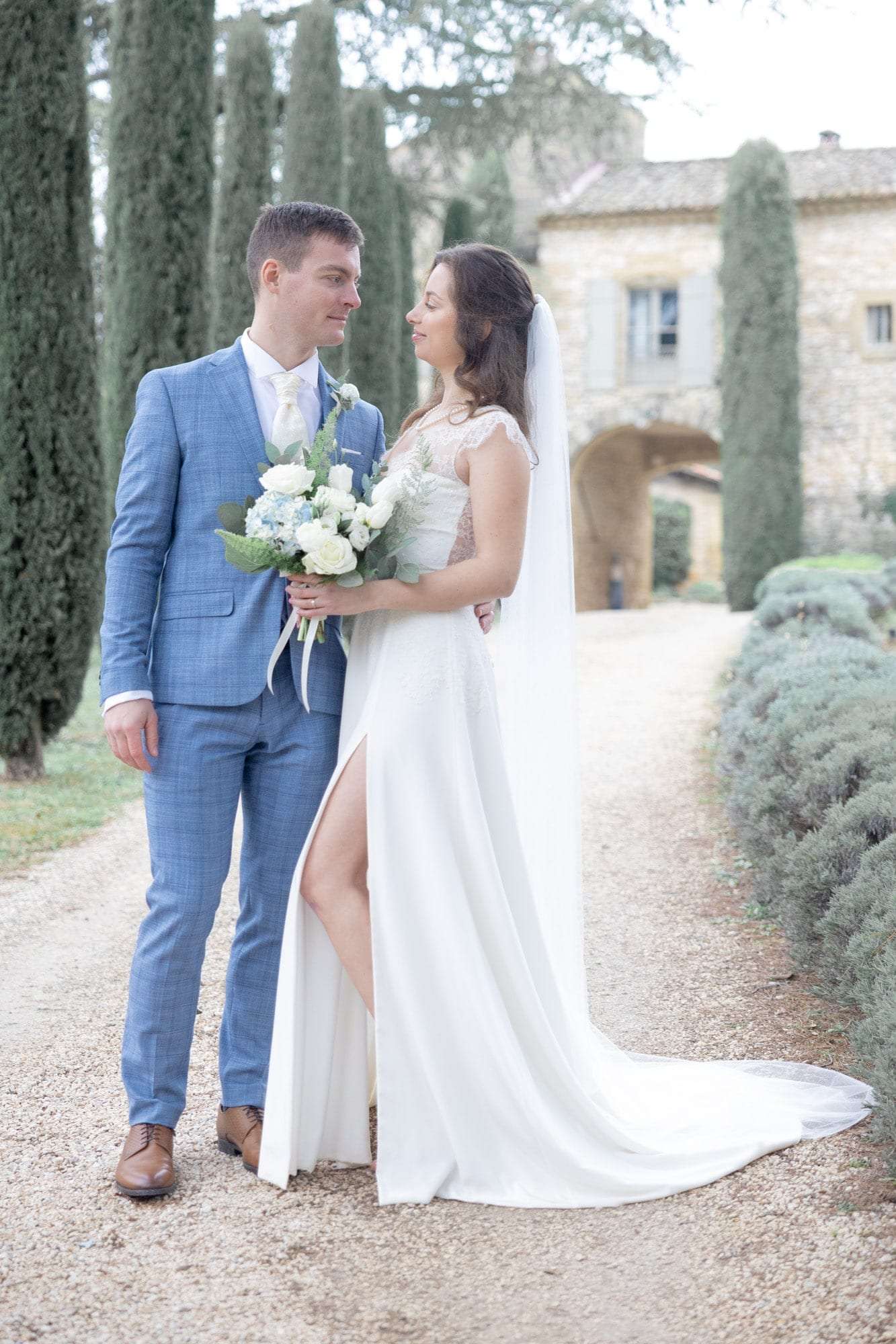 Les mariés dans une allée de cyprès d'un domaine provençal