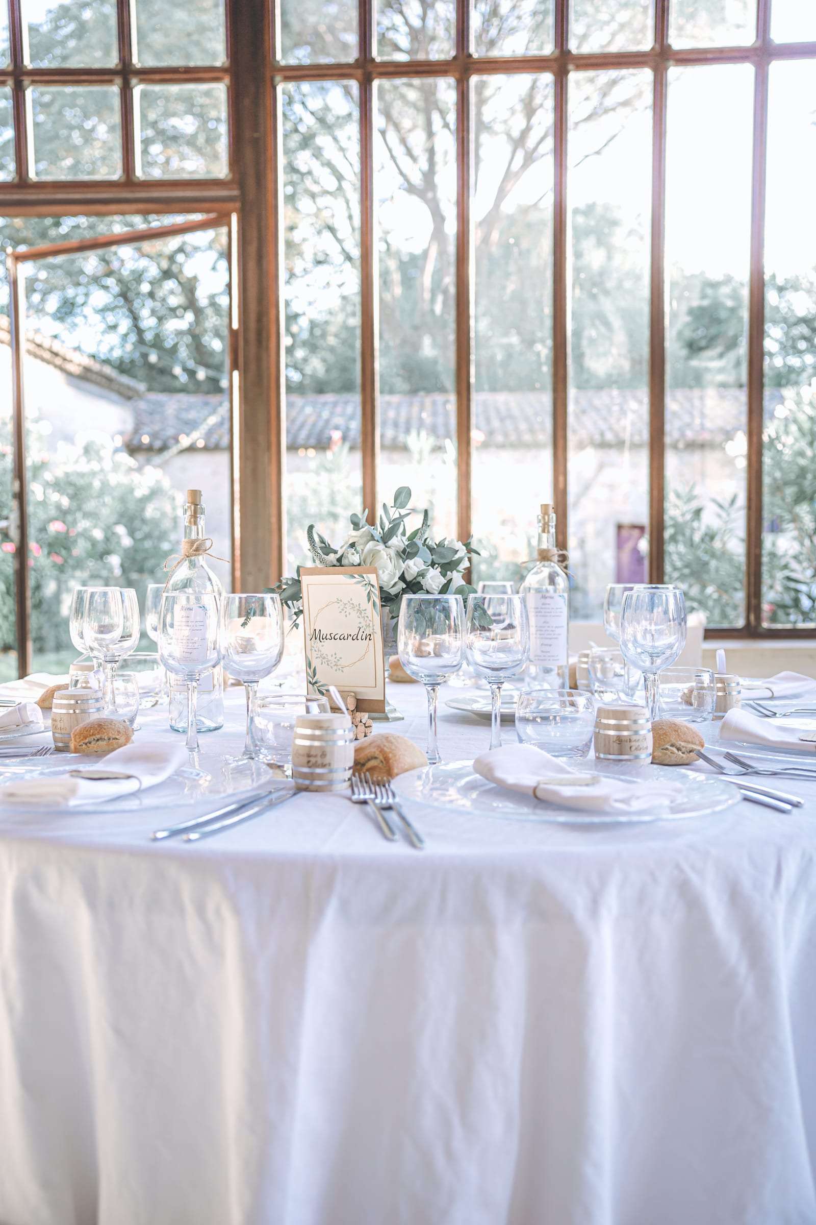 Salle de réception sous verrière, tables rondes nappées de blanc