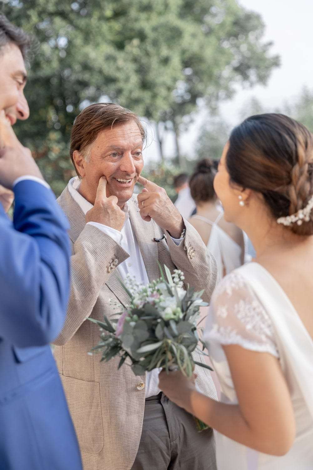 Les invités rient autour des mariés à la sortie de la cérémonie