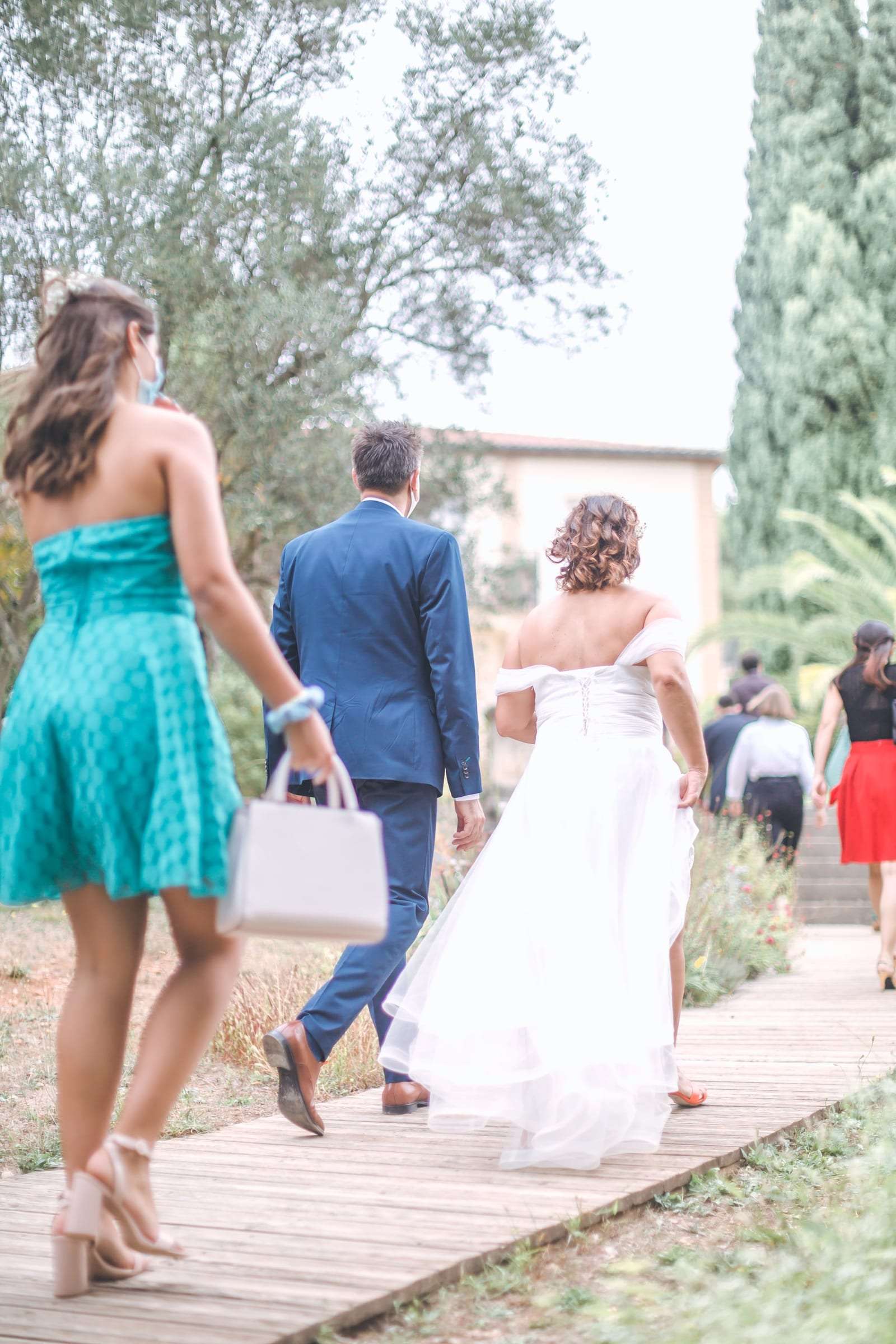 Les mariés traversent le jardin au milieu de leurs invités