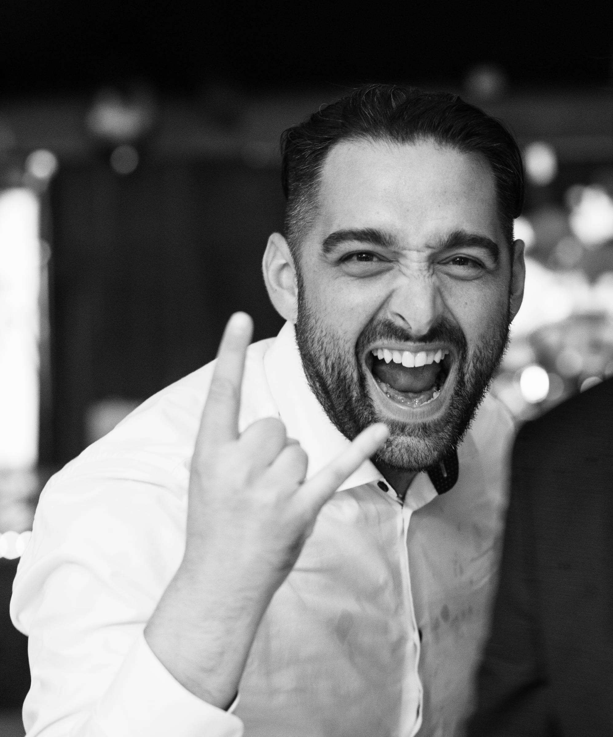 Photo noir et blanc d'un invité qui fait le signe rock sur la piste