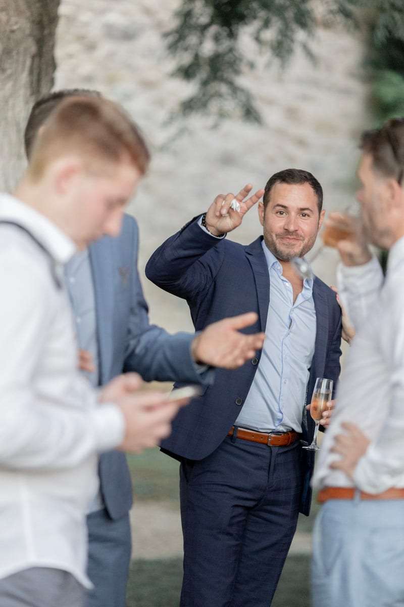 Des invités plaisantent, verre à la main
