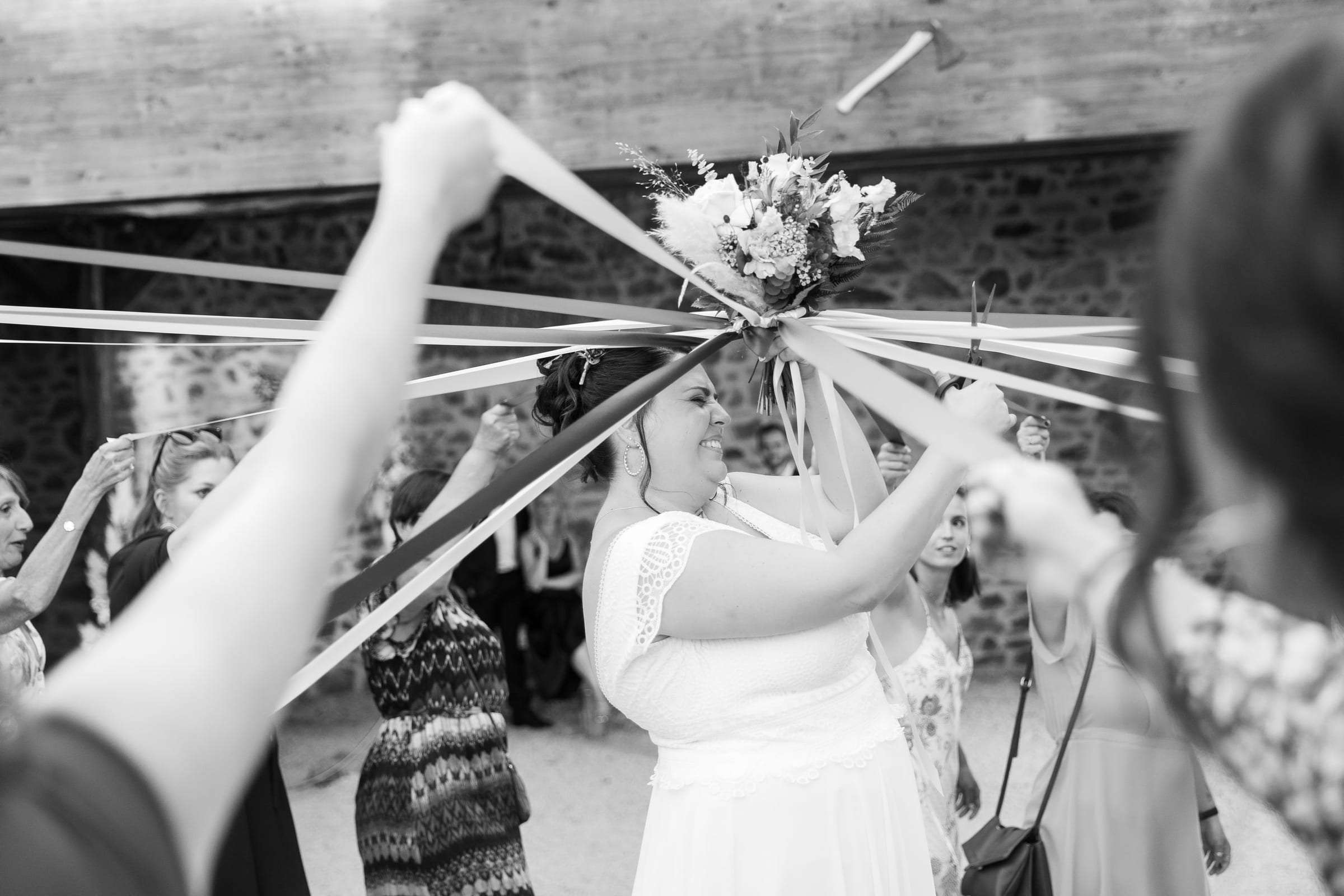 Photo noir et blanc d'un lâcher de rubans autour de la mariée